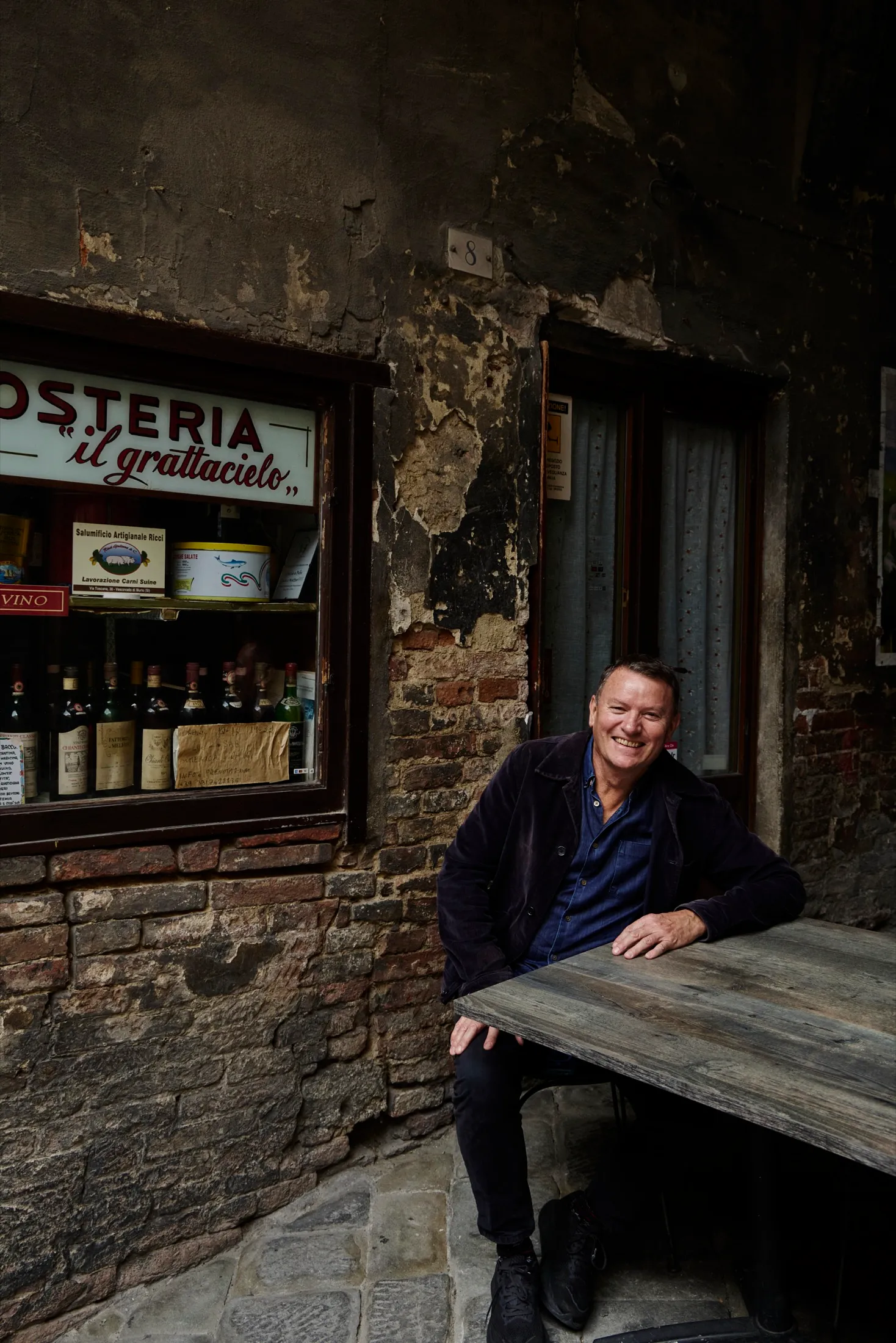 Theo Randall walking down a Tuscan street with market shopping, behind the scenes of The Italian Table.